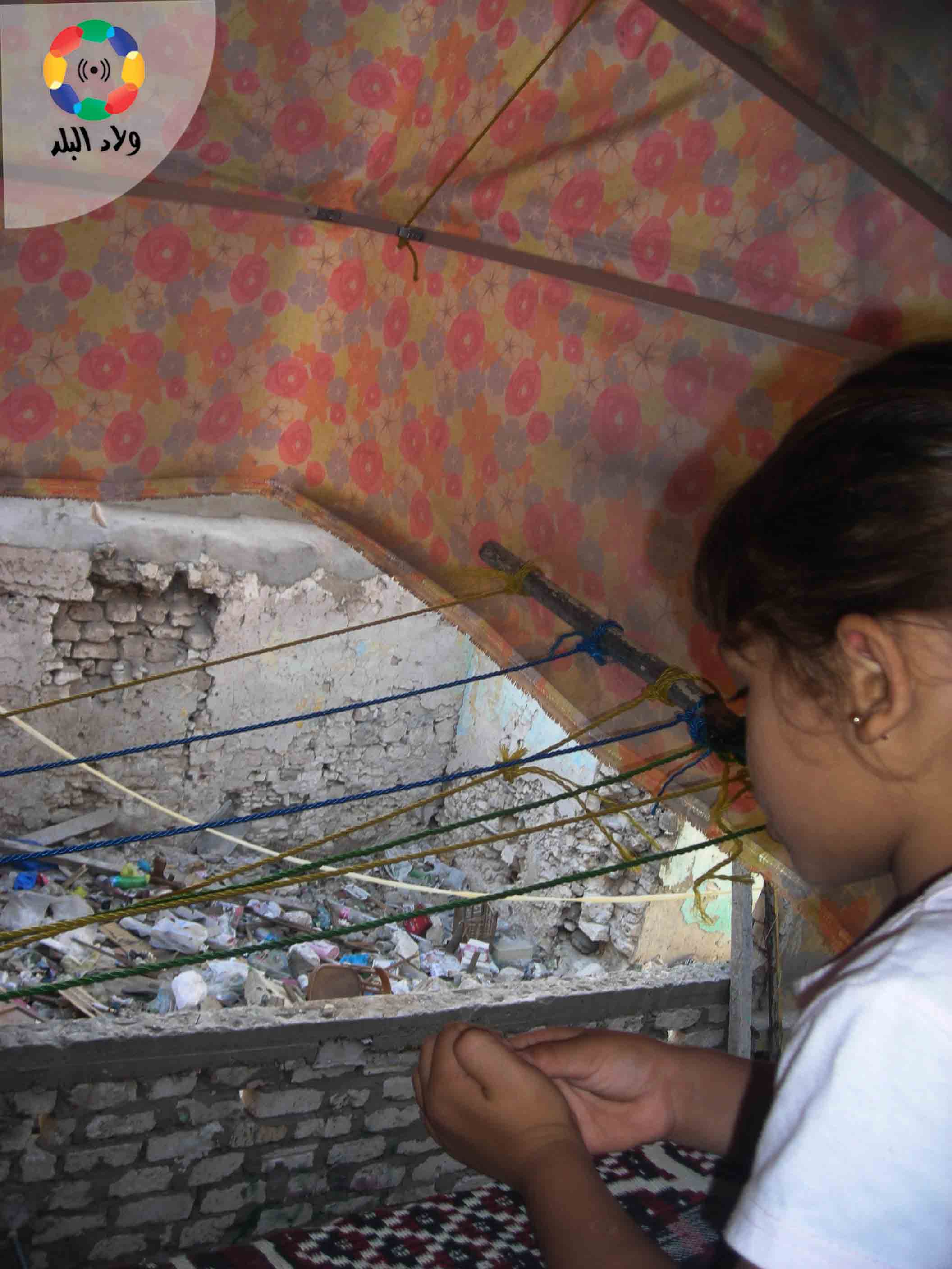 ريتاج تنظر الى المنزل المهدم