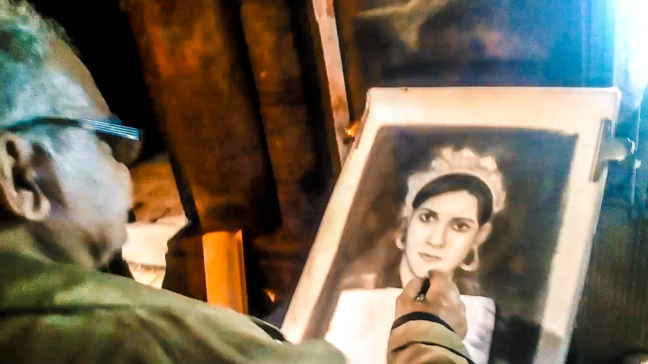 عم مصطفى يرسم إحدى لوحاته