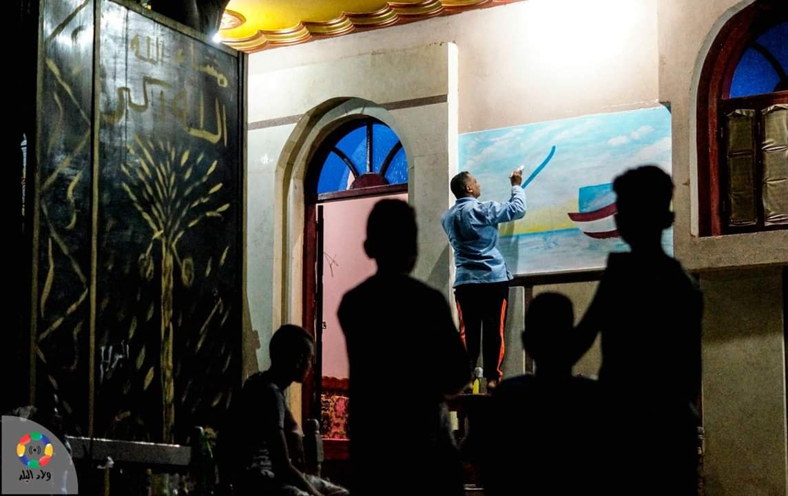 أطفال يشاهدون رسم جرافيتي الحج