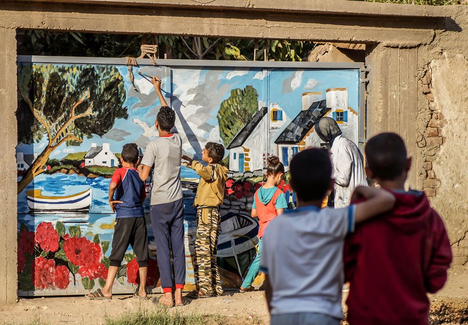 بأيديهم الأطفال يرسمون الجدارية- تصوير: أحمد دريم