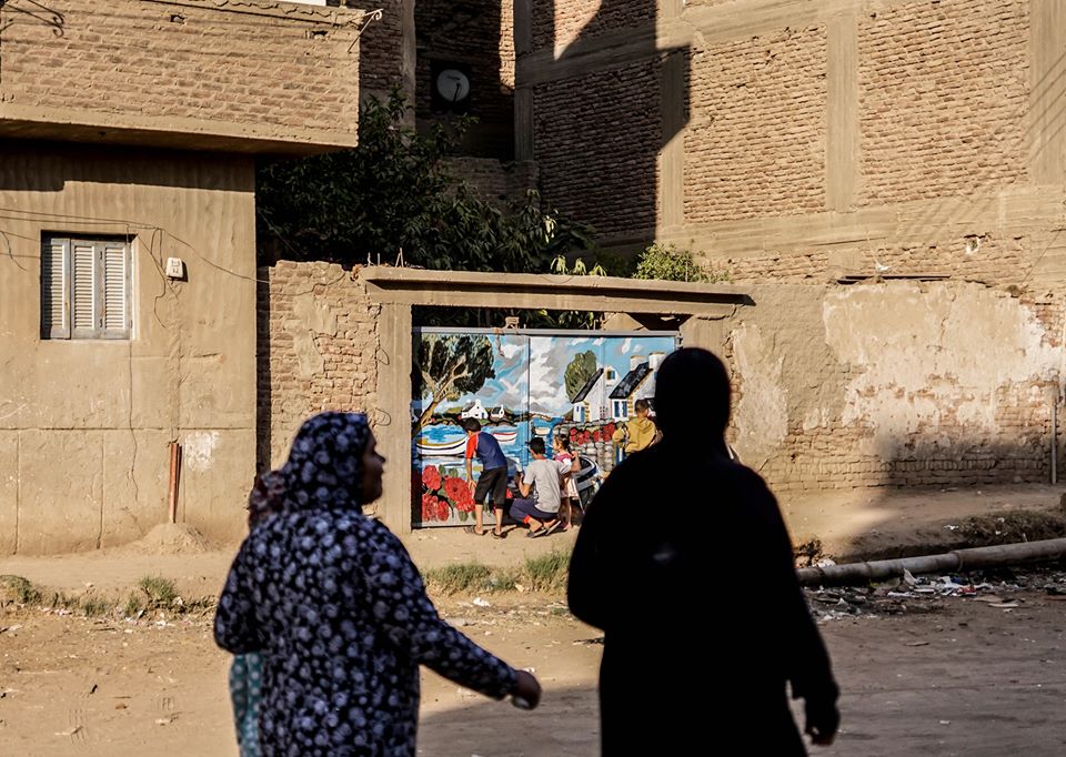 سيدات القرية يشاهدون الرسم من بعيد- تصوير: أحمد دريم