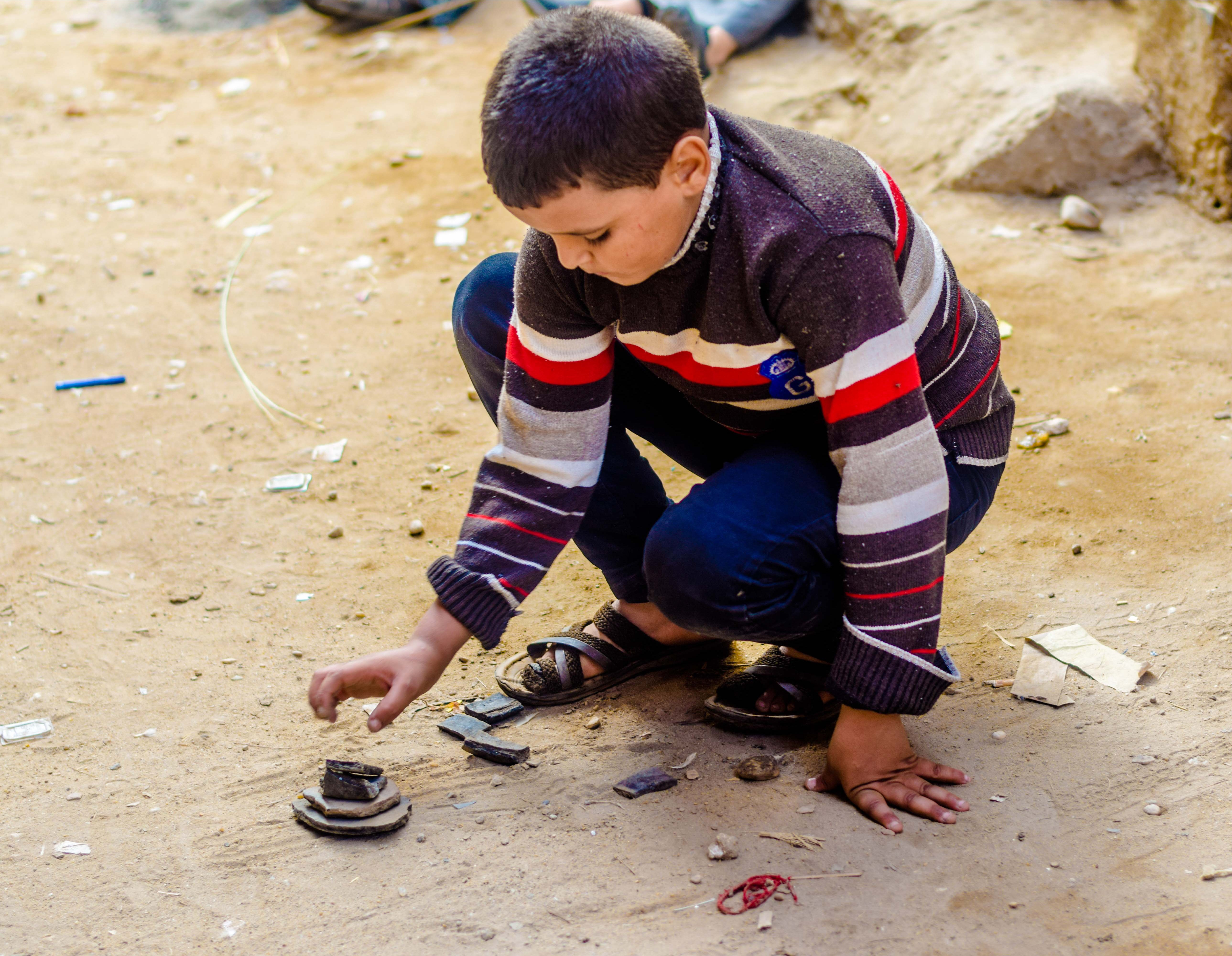 طفل يلعب السبع شقفات