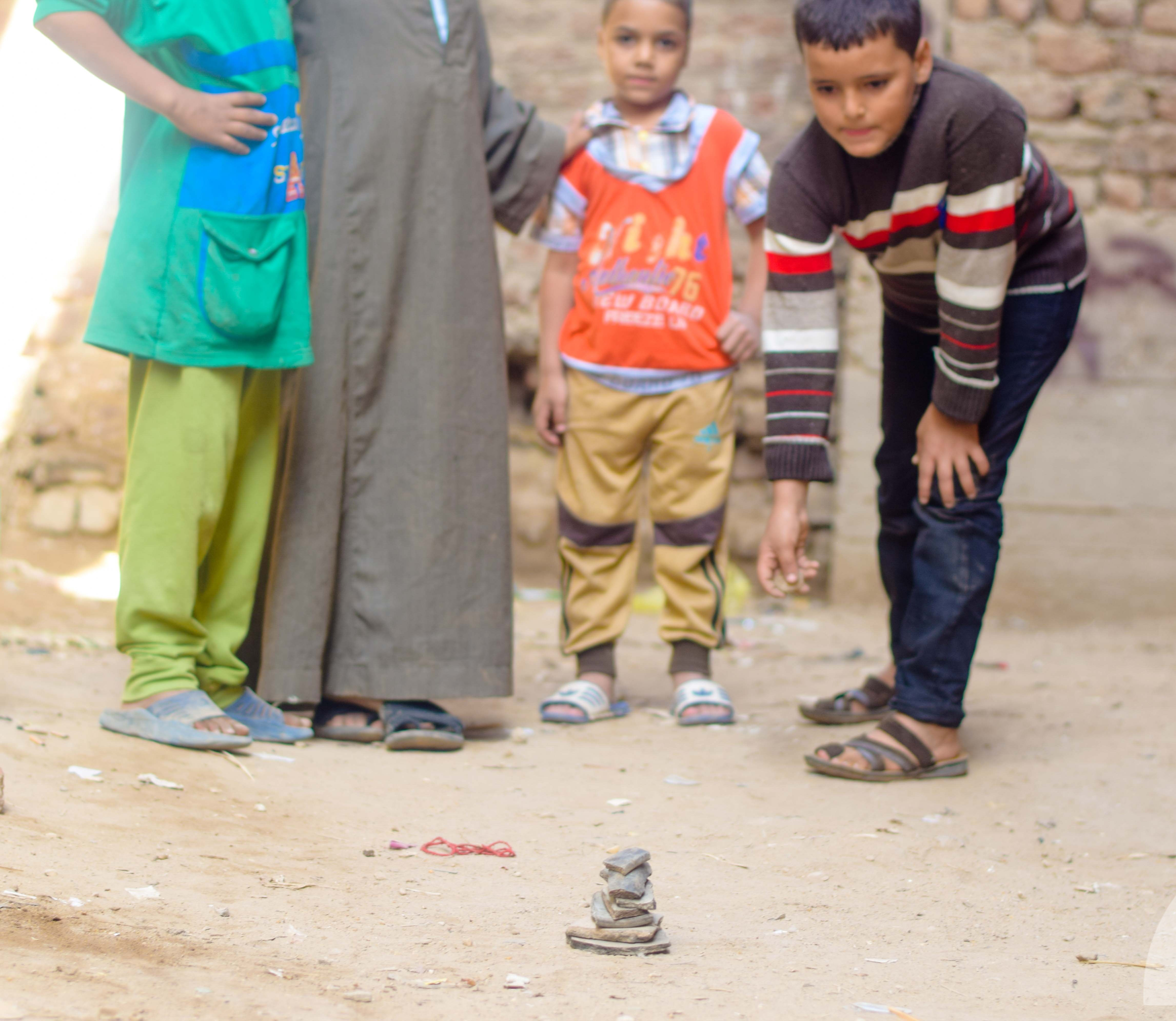 اطفال يلعبون السبع بلاطات