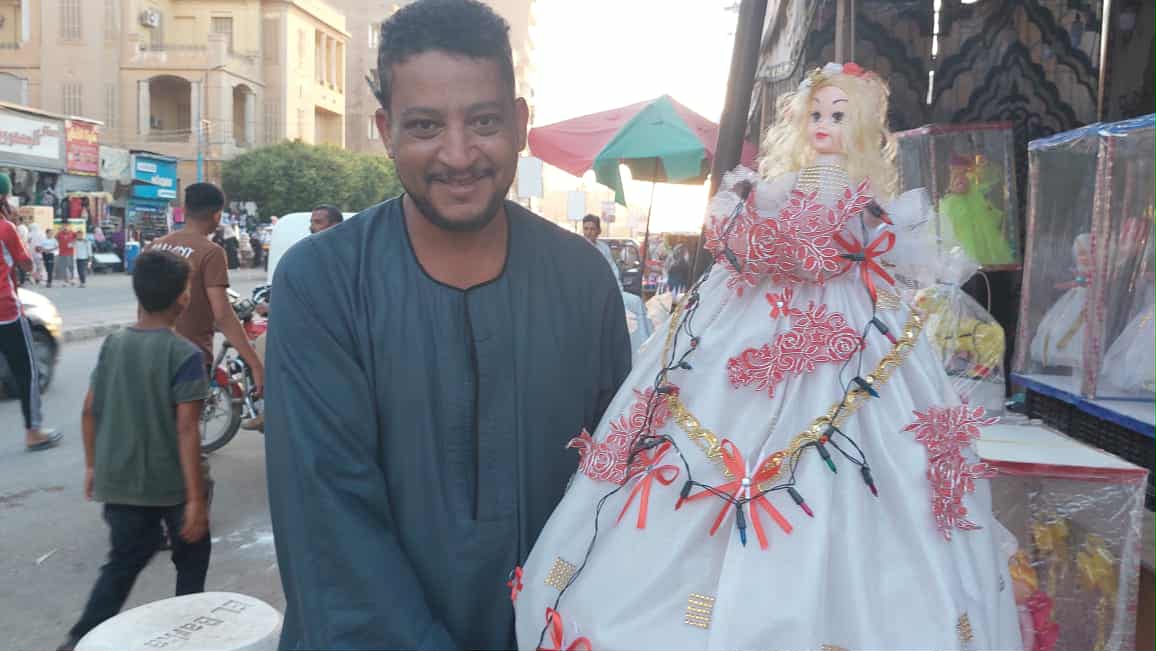 أحمد الرواي بائع الحلوي مع العروسة قطر الندي - تصوير: أسماء منتصر
