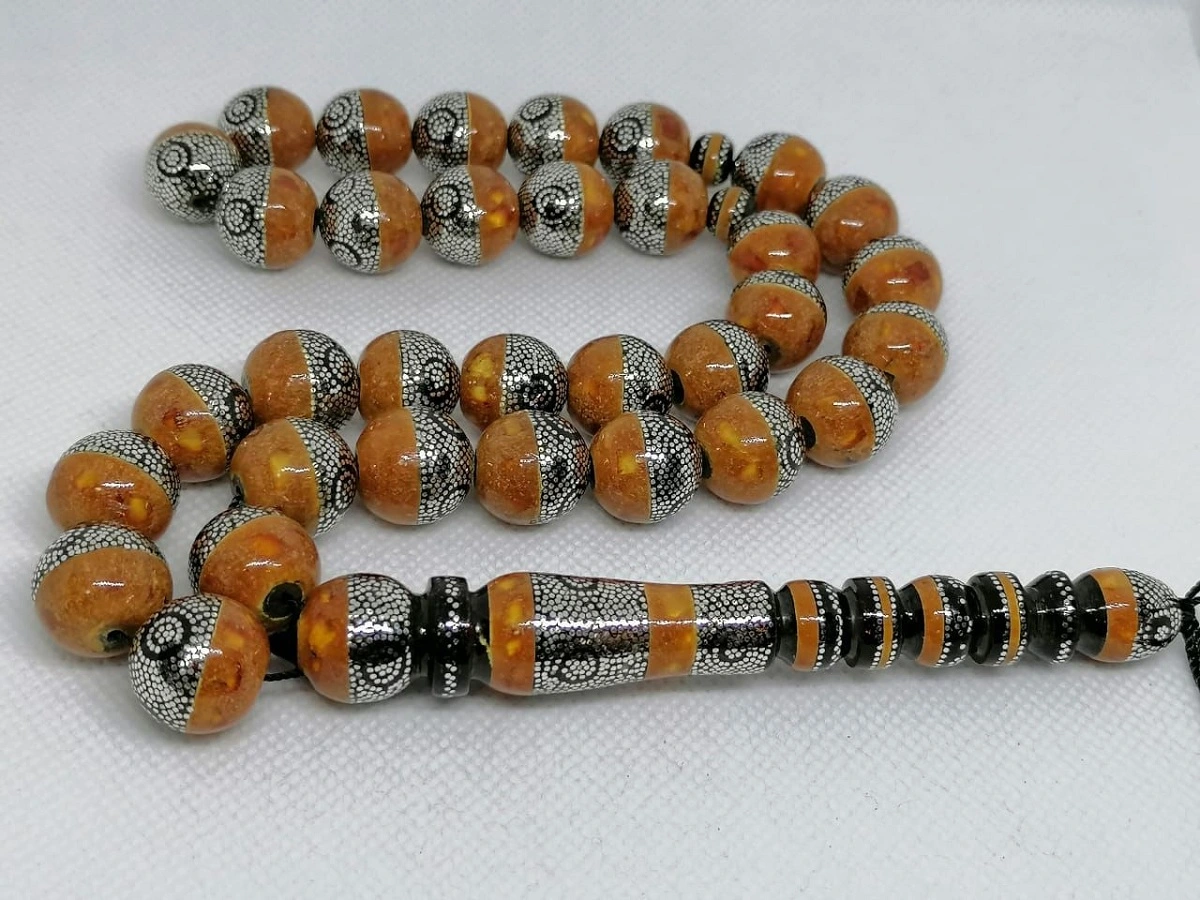 سبحة من اليسر والكهرمان مطعمة بالفضة.. الصورة من صاحب ورشة تصنيع السبح