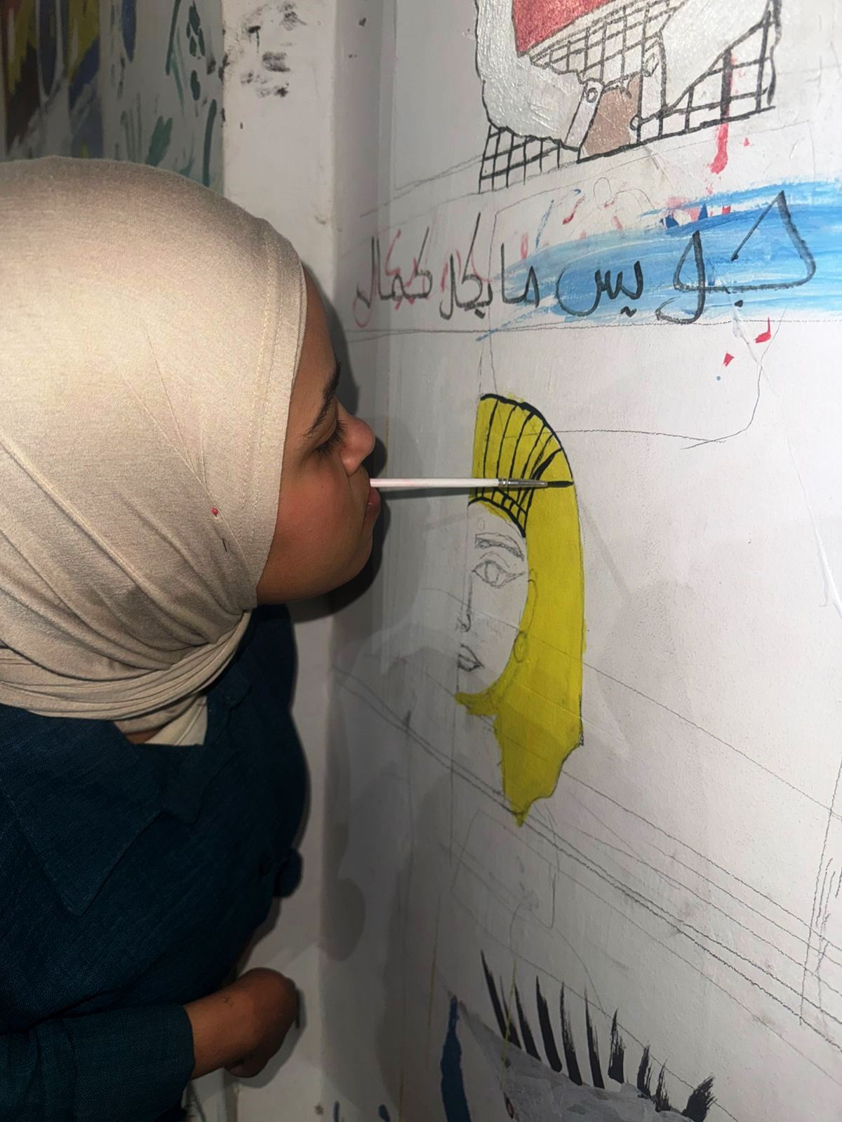 الفنانة بسملة فخري ترسم علي الجدارية.. تصوير: وفاء أمين